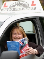 Diane Hall with her book in her driving school car
