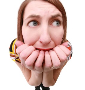 A fisheye image of a scared woman biting her nails.
